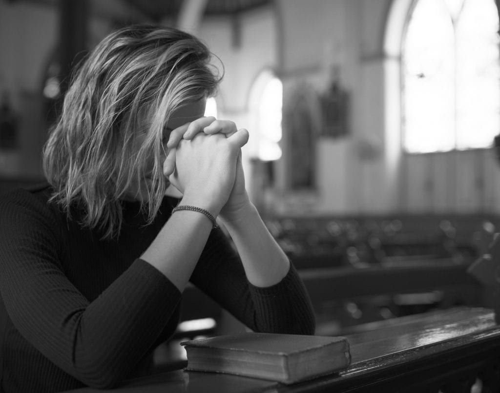 Woman praying in the church grayscale