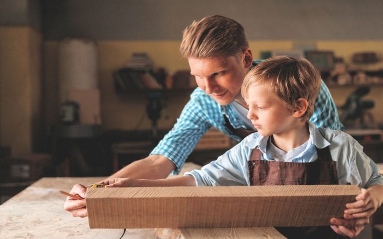 Young father and a little son at work in the carpentry